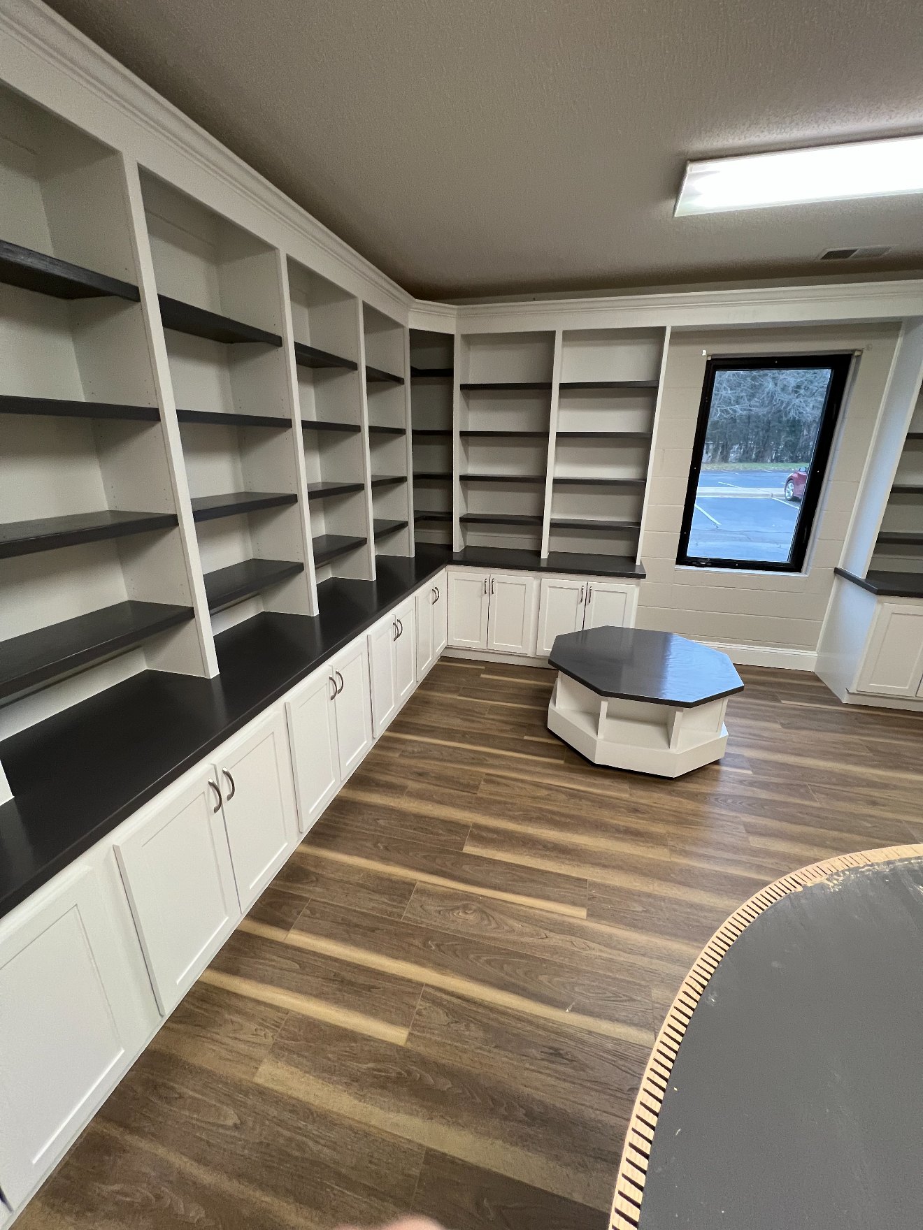 Built-in library and office cabinetry with open shelving and custom octagonal coffee table