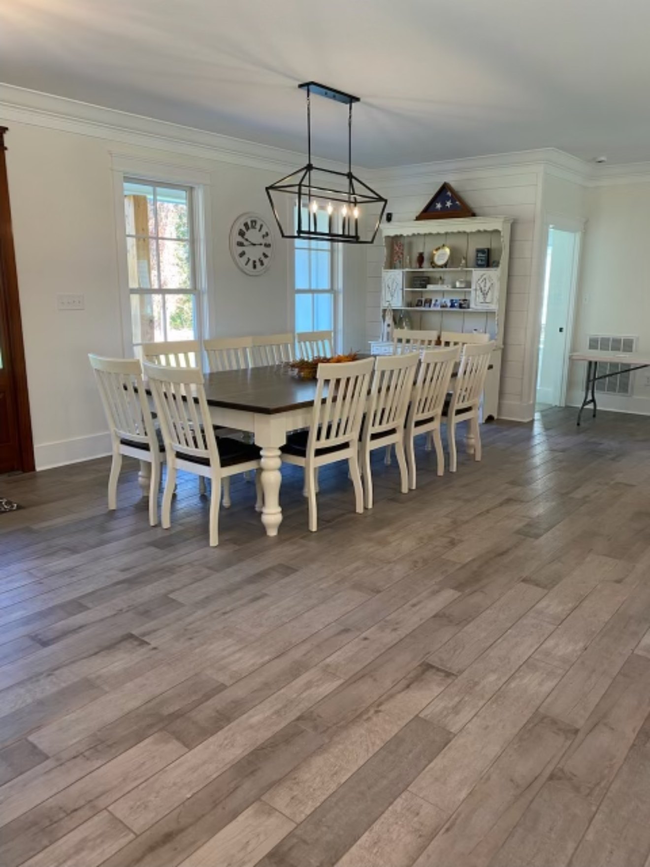 Finished dining room with crown molding, board-and-batten wall detail, and hardwood flooring