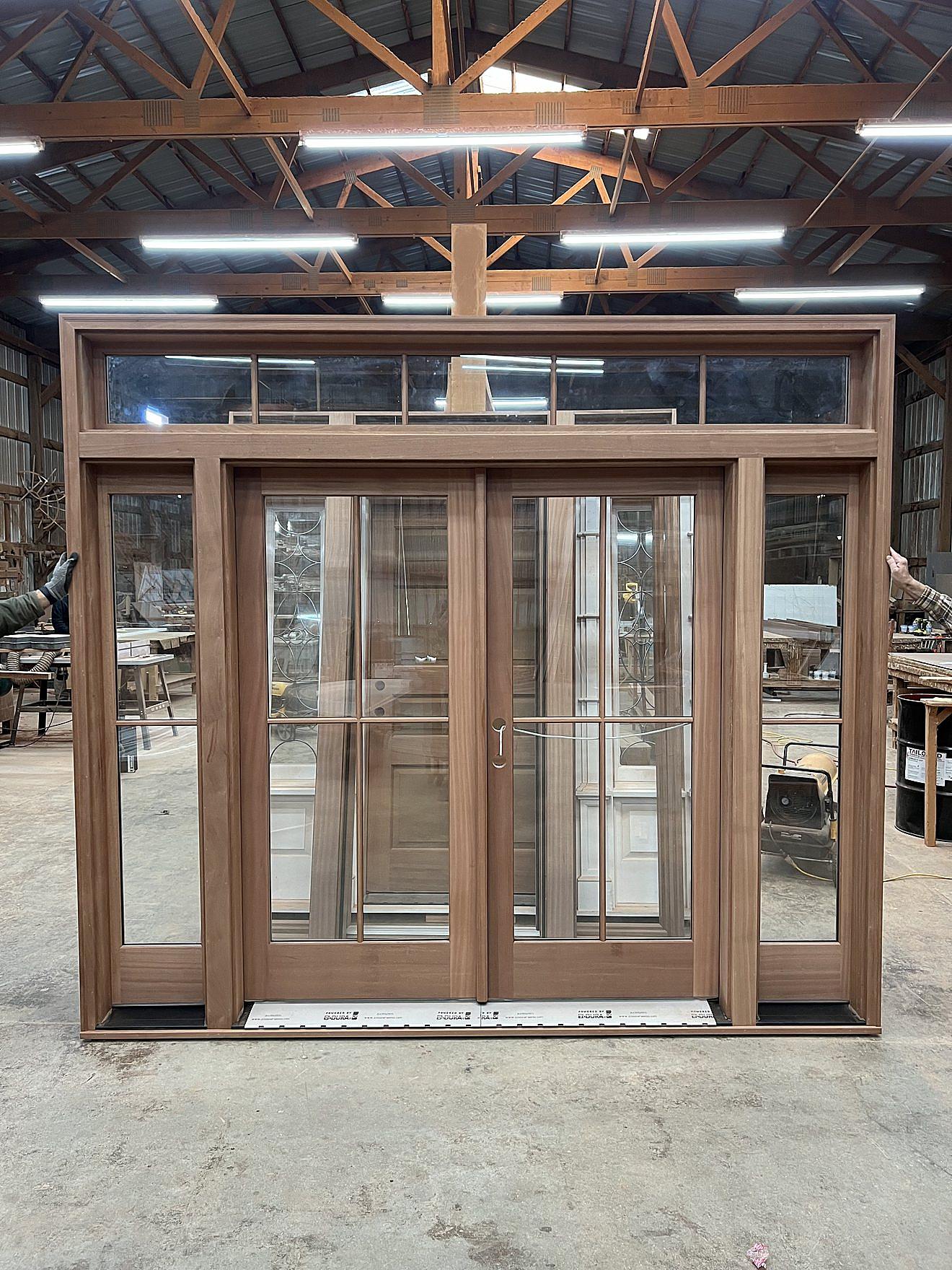 Handcrafted walnut French door with decorative glass sidelights and a transom window, built in the workshop